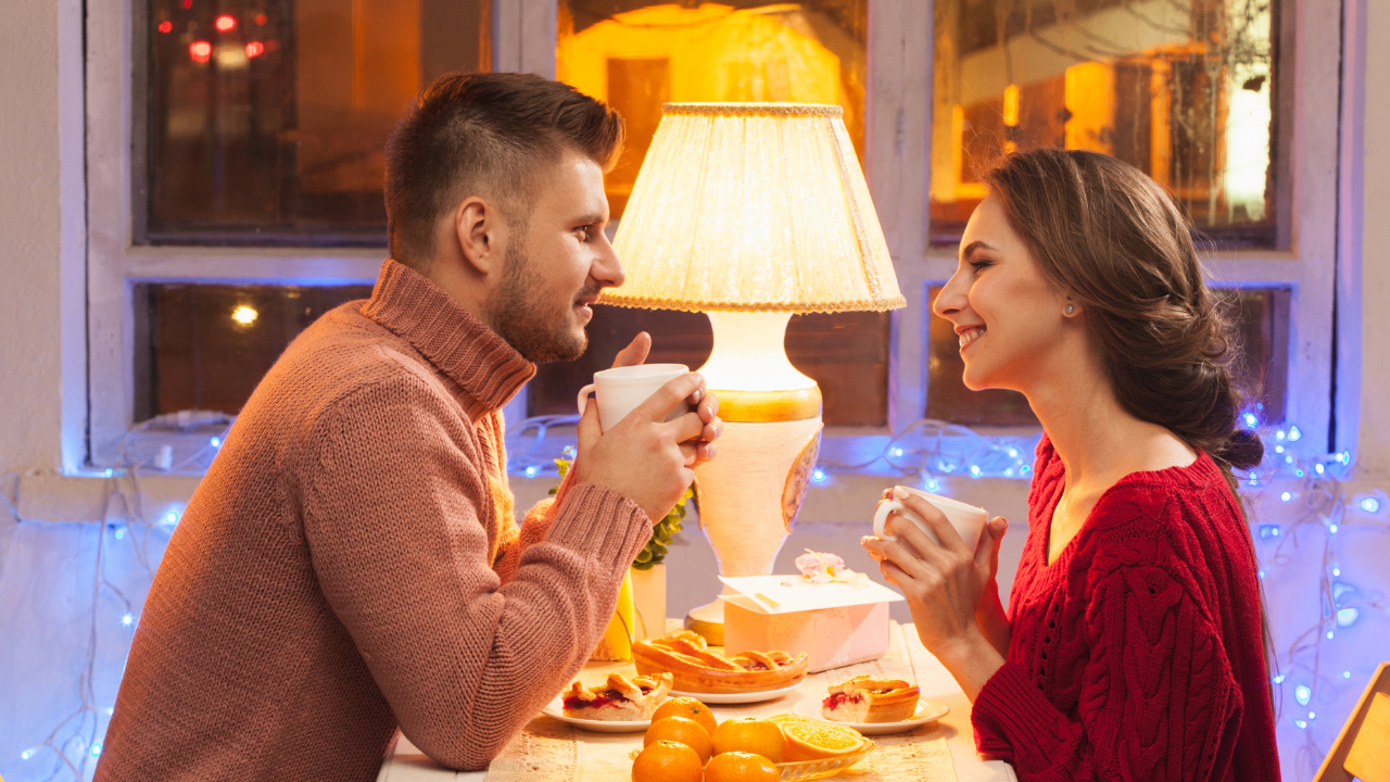 This image captures a warm, cozy date setting, where two people enjoy drinks and treats. It reflects that smooth moment but also brings up the question: *what to ask her on a date?