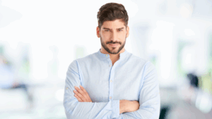 Confident man standing with arms crossed, representing how to build confidence naturally through self-belief and presence.