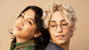 This image portrays emotional connection through a calm, intimate moment between two people leaning on each other with soft expressions.