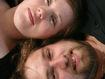 Close-up of a couple lying side by side with contrasting features, representing the theme of do-opposites-attract-in-relationships through visual and emotional connection.