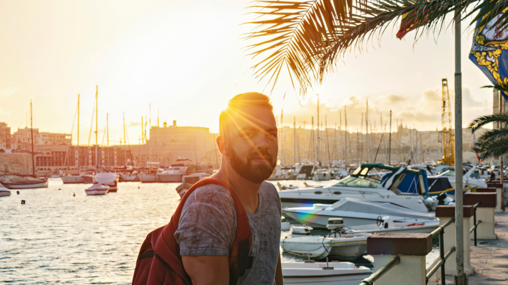 Introverted man walking along a marina at sunset, preparing to approach women confidently