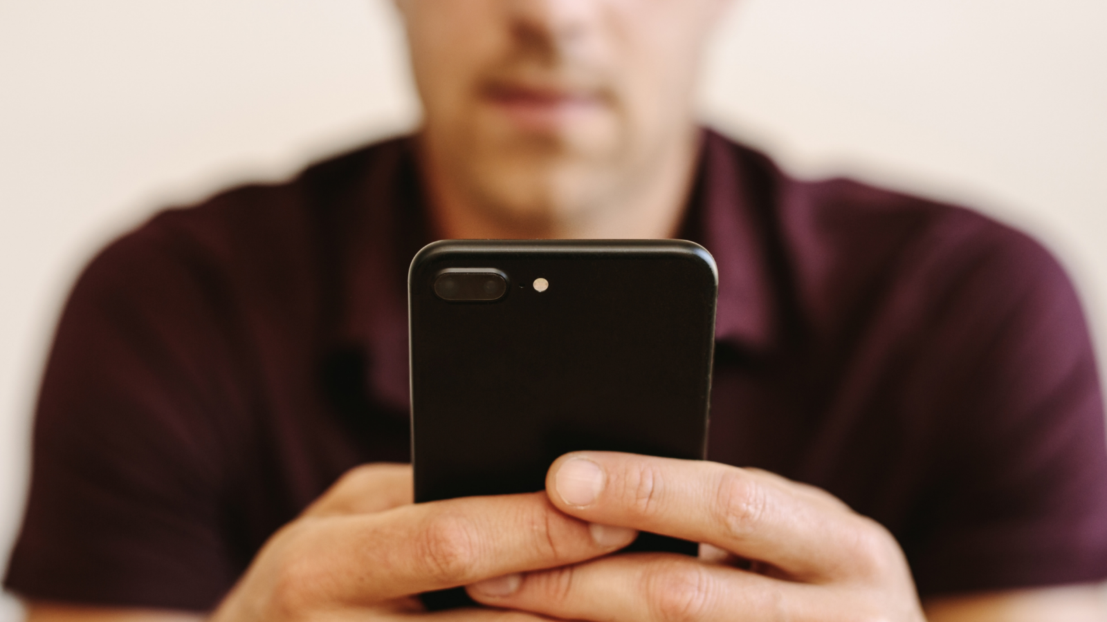 Close-up of a man holding a phone editing his dating profile