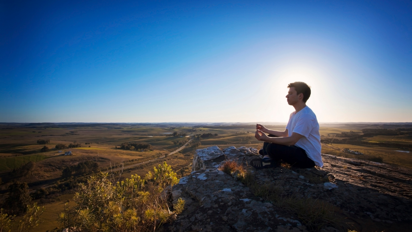 Man healing his heart chakra after a breakup, sitting alone in nature